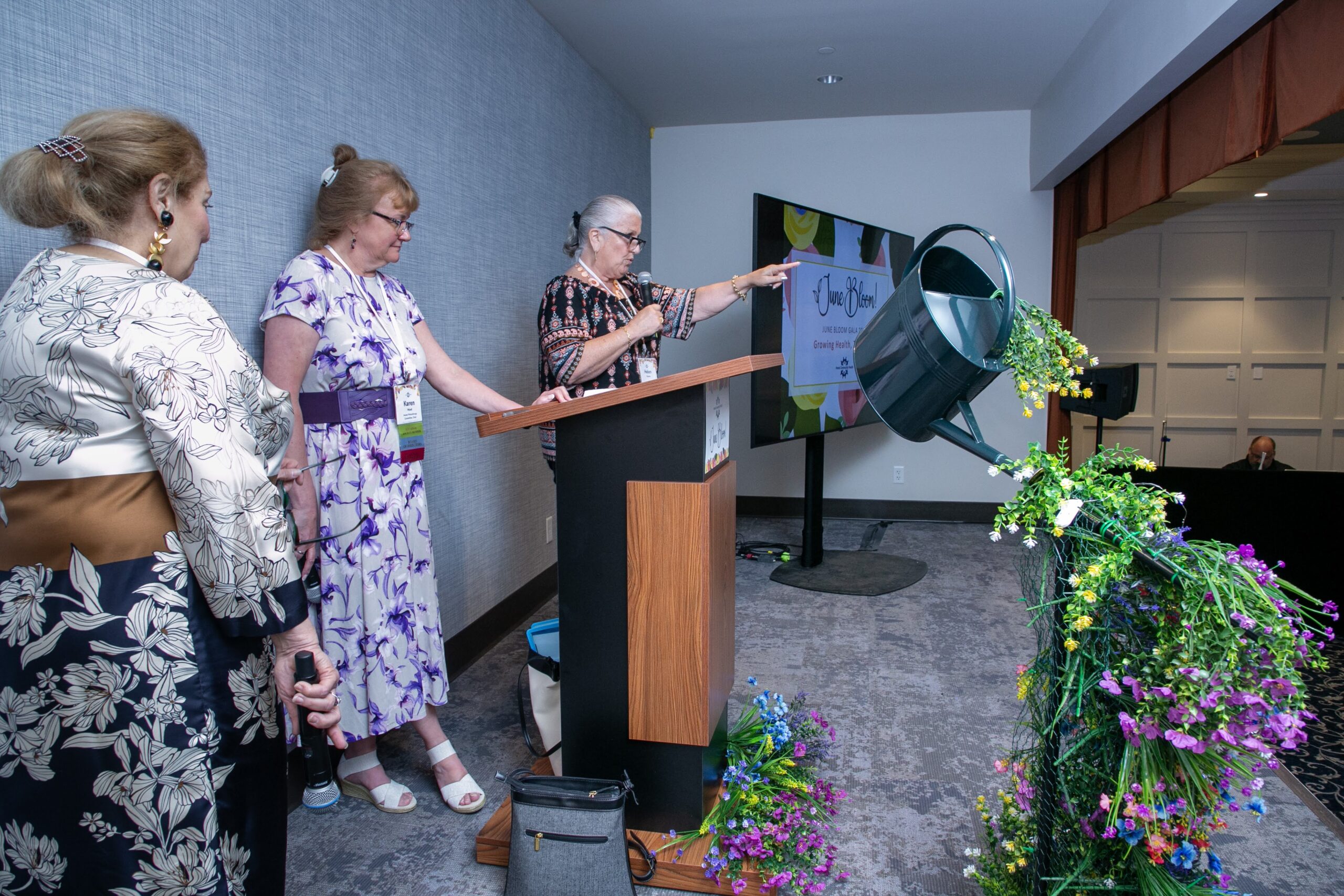 Photo 12:  Members of the Planning Committee (Phyllis Dohanian; Karen Ward, Chair; Helen Fatseas) announcing Silent Auction Winners